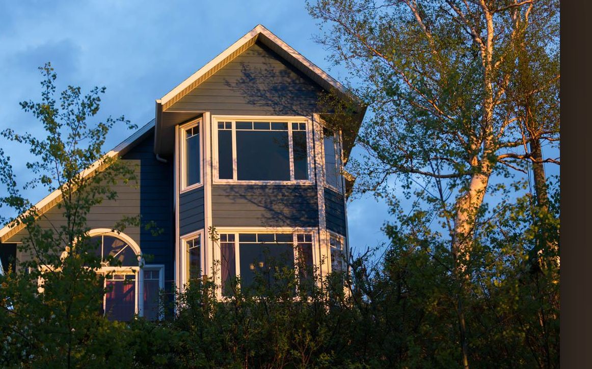 La maison dans la lumière du soir, entourée d'arbres